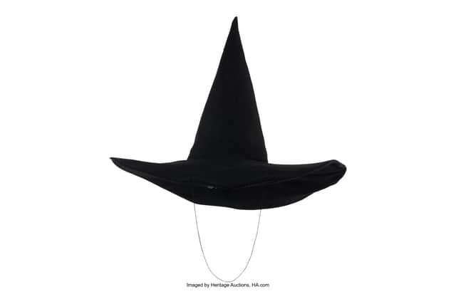 The wool hat measures nearly 14 inches high with a 19.5-inch diameter brim. It also has a 22-inch elastic chin strap worn by Hamilton during flying scenes to keep it secure.