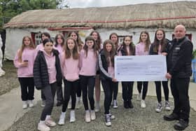 Sixth class pupils from Scoil Chroi Naofa, formerly St Patrick’s Girls School in Carndonagh, pictured presenting Pat Doherty from Doagh Island famine village with a cheque from a bake sale