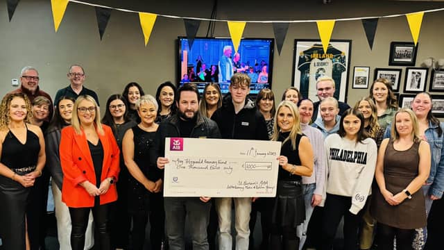 Ollie Harvey and Tina Higgins present the cheque for Greg Fitzgerald Recovery Fund to Greg's son Leon
