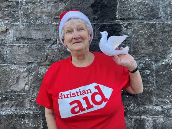 Lilian Webb hanging a 'Dove of Peace' on her Christmas tree