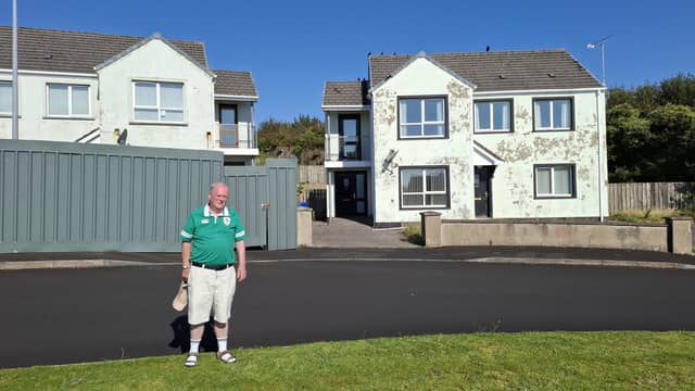 Councillor Martin Farren in front of some of the closed down properties in the Ard na Guala Duibhe estate in Moville