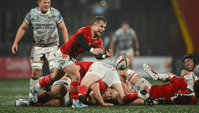 Craig Casey, of Munster Rugby, gets his pass away at a wet Virgin Media Park in their URC bonus point win over the Ospreys on Saturday evening