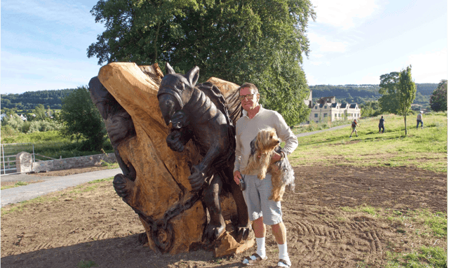 Raymond Dowley and his dog Teddy standing beside the sculpture of the griffins in Castle Park in Carrick-on-Suir. Picture Anne Marie Magorrian