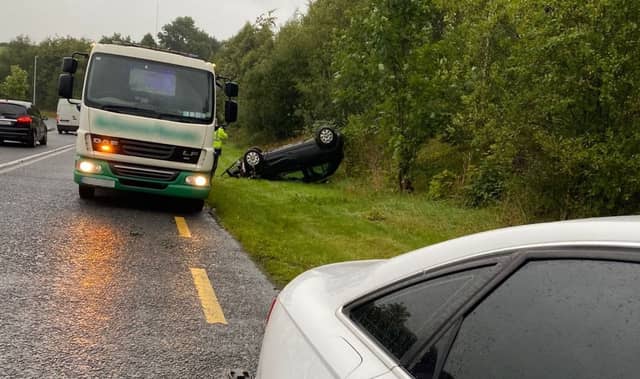 A photograph posted on social media by gardai shows a car overturned and on its roof to the side of the road with a recovery truck also present