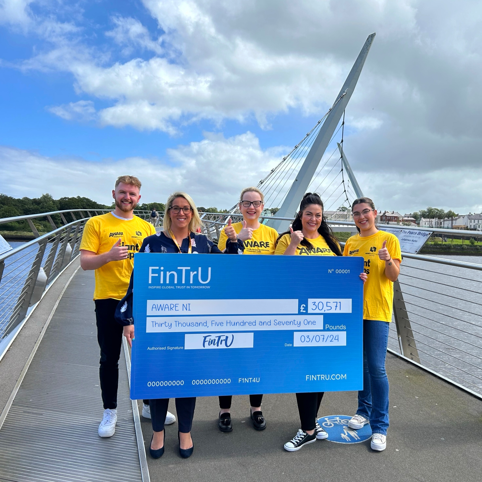 AWARE NI Head of Fundraising Leigh Osborne being presented with a cheque donation by FinTrU staff from its Derry office