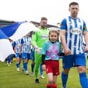 Finn Harps captain Tony McNamee leads the teams out with the match mascots before Monday’s game. Photo Evan Logan