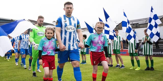 Finn Harps captain Tony McNamee leads the teams out with the match mascots before Monday’s game. Photo Evan Logan