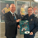 Bertie Smith presenting the frame to Rockwell College gamesmaster John Ryan