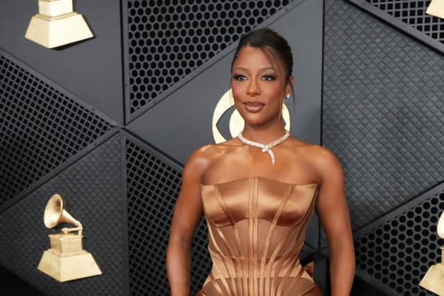 Singer-songwriter Victoria Monét, who won three Grammys for best new artist, best non-classical engineered album, and best R&B album, was styled by Kollin Carter in a custom satin brown Versace, with exposed corset detailing, pointed bustier and train.