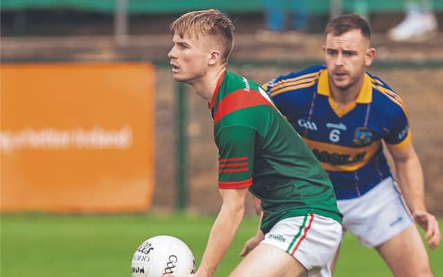 Milltown Cian Buckley weights up his options for a pass as Grangenolvin Dylan Costigan gives cover in the Tom Cross JFC. Photo: Sean Brilly