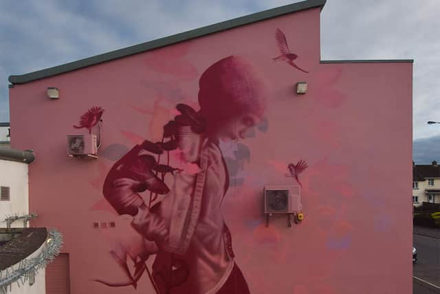 The artwork features a young person walking in nature. The figure blends together with the foliage to represent growth with birds taking off into the sky to represent achievement.