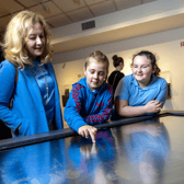 Teacher Eileen McGiff with AJ Buckley and Maria McMahon, 4th class pupils from St Mary's NS, Limerick  city, using the interactive timeline to explore the story of clay and ceramics at 'Made of Earth’