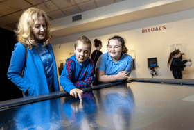 Teacher Eileen McGiff with AJ Buckley and Maria McMahon, 4th class pupils from St Mary's NS, Limerick  city, using the interactive timeline to explore the story of clay and ceramics at 'Made of Earth’