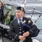 A lone piper leads the funeral cortege of Martin McGill PHOTO: NORTHWEST NEWSPIX