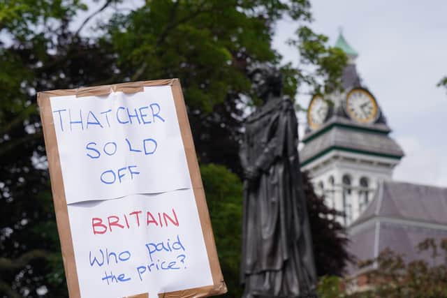 Shortly before the ceremony, a woman threw coffee in the direction of the statue, while others displayed placards such as “Grantham resident against Maggie” and “Thatcher sold off Britain, who paid the price?”