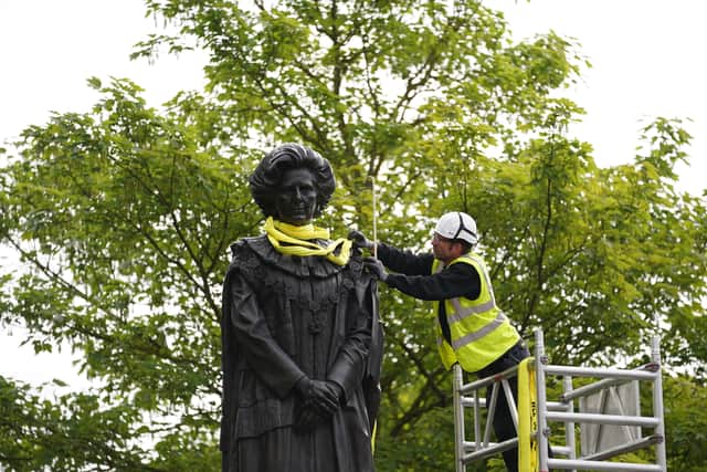 The statue was lowered into place in the town amid previous threats of “egg throwing” and was booed by passing motorists.