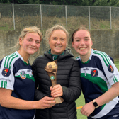 Eve Schneider, múinteoir Caoimhe Esselmont, and Ríona Ní Chrualaoich with the league winners’ trophy
