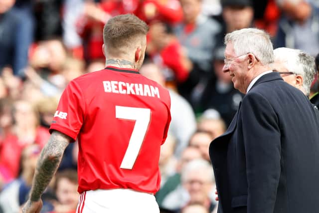 Sir Alex is standing beside the young footballer, wearing a striped red-and-black tie.