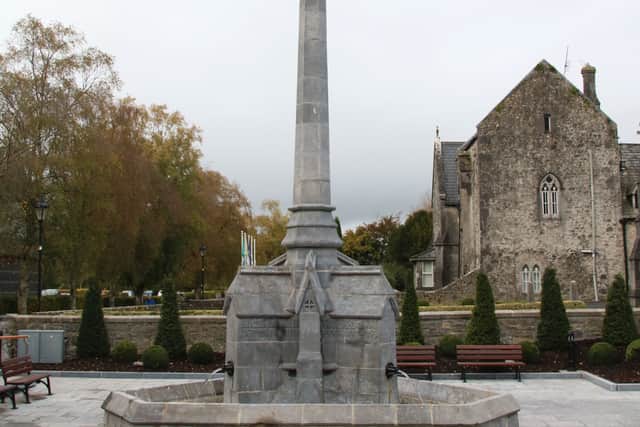 The fountain is set within a cut limestone pentagon-profile basin with carved copings. It has a tapering four-sided obelisk style shaft surmounted by Celtic cross with carvings in relief and to the base. The plinth comprises projecting gables with trefoil and cross motifs and carved lettering in relief.