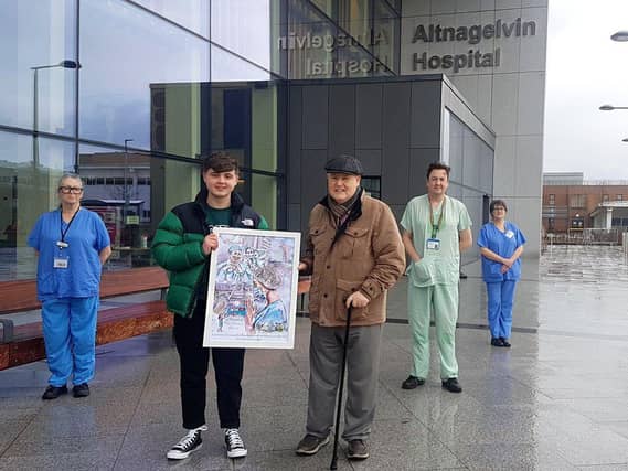 Ethan pictured with his grandfather presenting one of his artworks to staff at Altnagelvin.