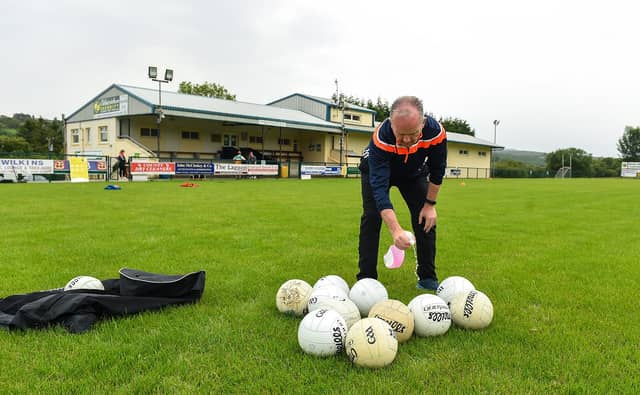 Paul Gallagher, team official, sanitising the footballs before a Glenswilly GAA Club training session last summer Picture: Oliver McVeigh/Sportsfile