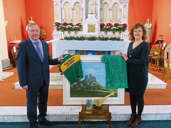 Joe Lyons and his successor Sheila Hayes, with a gift of a signed Limerick GAA jersey, a Kerry jersey, and a picture by local artist Jim O’Farrell