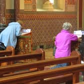 People writing petitions this week at the Redemptorist Church which is streaming the annual Novena online