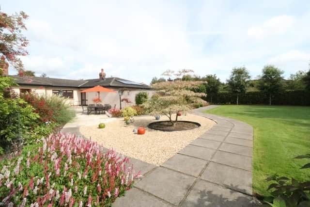 Outside the property includes a tarmac driveway with space for several cars and extensive landscaped gardens to the rear with a glass house, garage with half loft storage, shelved and fitted work bench.
