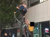 Late-night revelers climbing the Richard Harris statue. The base of the statue was also covered in litter