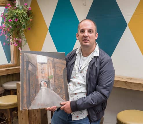 Artist Rob Norwood pictured with one of his paintings