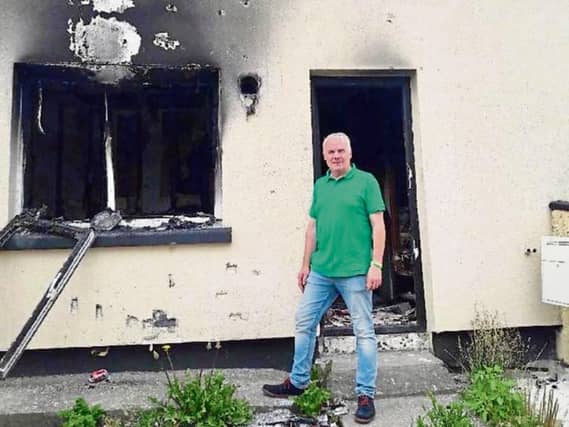 Cllr John Costelloe pictured outside one of the houses which was targeted