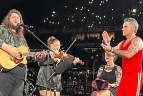 Longford Fiddle player Laura Doherty on stage last night with Robbie Williams and Garron Noone in Croke Park Picture: Facebook Fleadh Cheoil Longfoirt