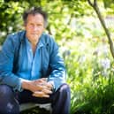 Chelsea Monty Don seated on a bench in a garden