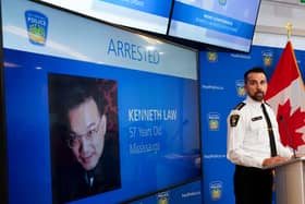 A police officer in Canada with the image of Kenneth Law displayed on screen