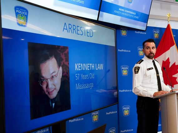 A police officer in Canada with the image of Kenneth Law displayed on screen
