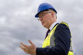 Side view of John Swinner, who is wearing a hi-vis vest and hard hat while speaking