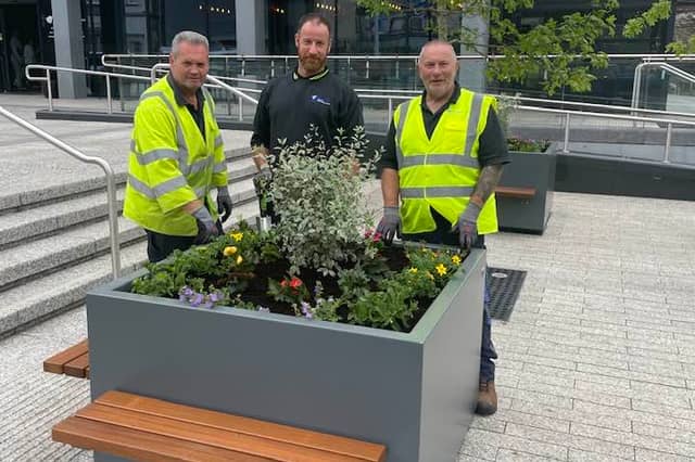 Council staff pose with the planters following their installation