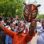 Supporters wear and display cockroach masks during a protest in New Delhi, India