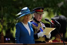 The King speaking, while in military uniform, with the Queen alongside him
