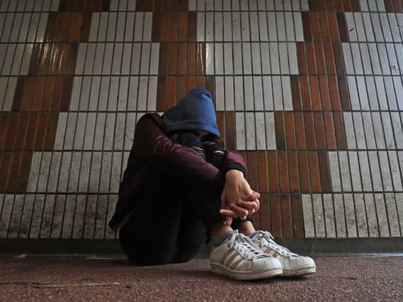 Teenager with head on knees