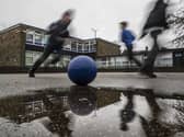 School children playing football in a playground