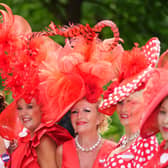 Racegoers wear red hats on Ladies Day