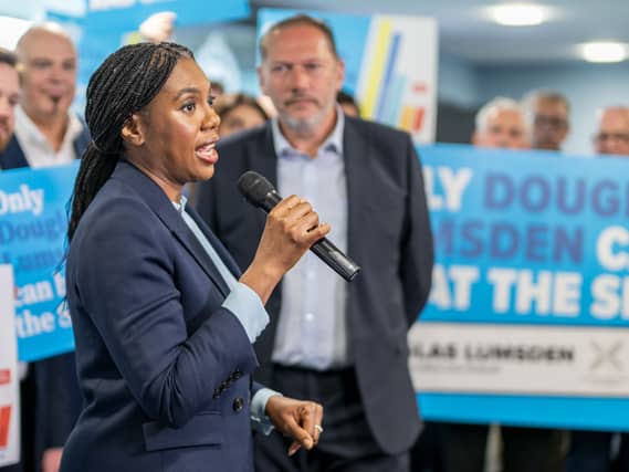 Kemi Badenoch speaking into a mic, as Douglas Lumsden looks on, in front of Tory supporters