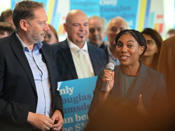 Kemi Badenoch speaking into a mic, alongside Douglas Lumsden and Tory campaigners