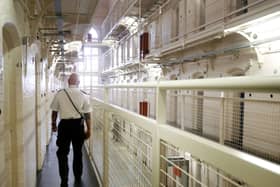 A prison officer walking along a prison wing