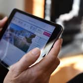 Close up of a senior woman holding an Apple iPad Mini looking at holiday information online