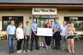 Pictured from left to right at the cheque presentation at the Key West Pub are:  Gary Walsh from Key West Pub, Breege Carney, members of the Moylette family Dwaine, Conor, Seamus, Cathal, Christina and Enda, Garda Mick Tolan, Pat Carolan from Carolan's Meats, Geraldine Moylette with Leon Moylette. 