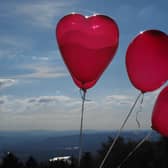 Helium balloons flying high in front of a blue sky