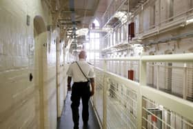 A prison officer walking along a prison wing