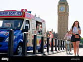 People with fans, drinks and ice cream in London